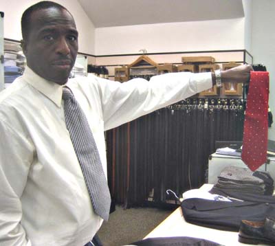 David Melton, assistant store manager with Men's Warehouse in downtown Silver Spring, holds up this silk tie, Newsline photo by Alan J. McCombs